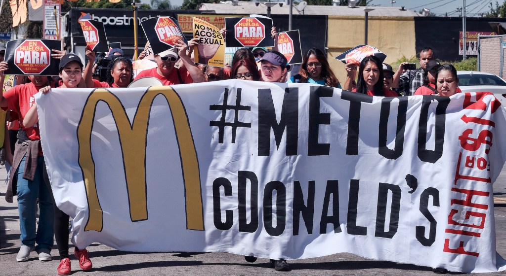 McDonald's workers carry a banner and march towards a McDonalds in south Los Angeles on Tuesday, Sept. 18, 2018.