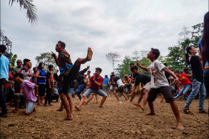 Danu (baju biru) sedang wuru dan menari penuh tenaga