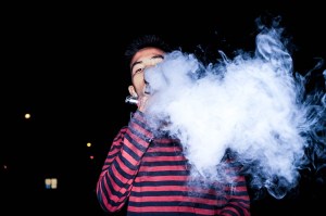 A young man using an e-cigarette