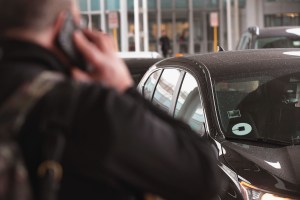 A single rider on the phone as an Uber driver approaches them.