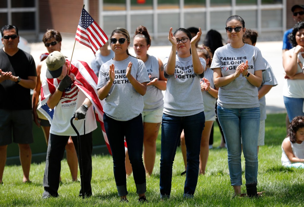 Activists applaud a rally to protest the Trump administration's immigration policies, Saturday, June 30, 2018, outside the Marshall County Courthouse in Marshalltown, Iowa. (AP Photo/Charlie Neibergall)