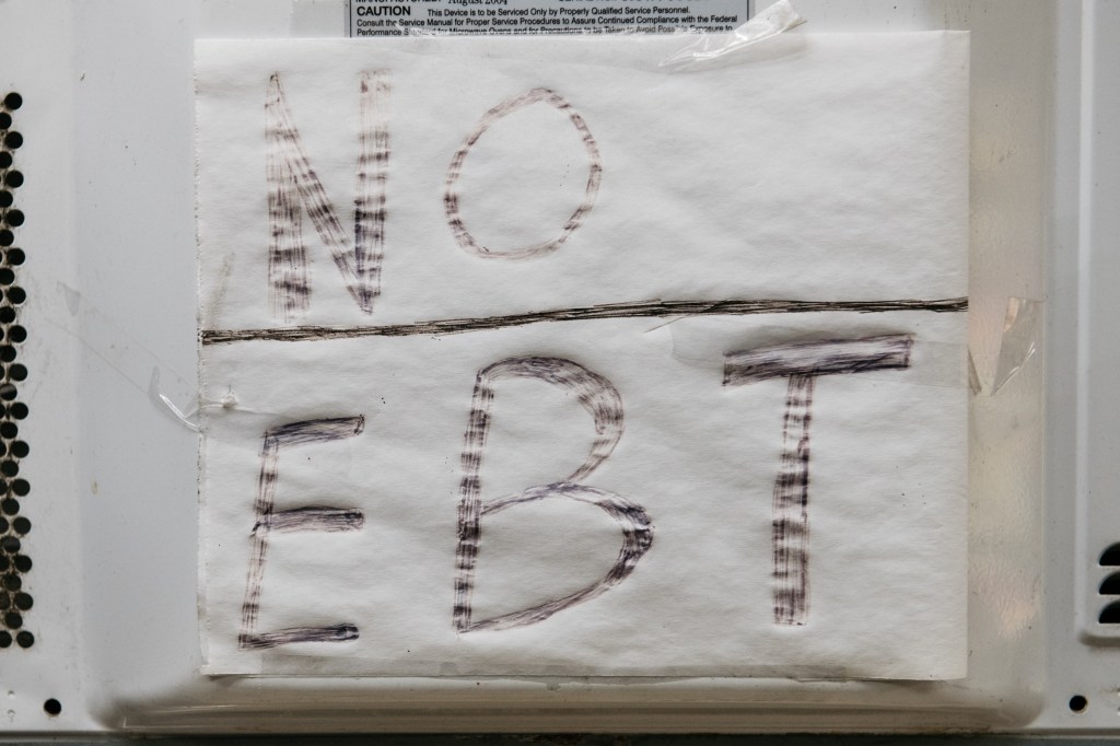 A "NO EBT" sign on a storefront window.