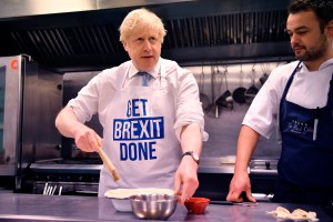 Britain's Prime Minister Boris Johnson prepares a pie at the Red Olive catering company while on the campaign trail, in Derby, England