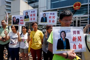 In this Friday, April 17, 2015 file photo, anti-Beijing protesters hold pictures of jailed veteran Chinese journalist Gao Yu during a rally outside Chinese central government's liaison office in Hong Kong.