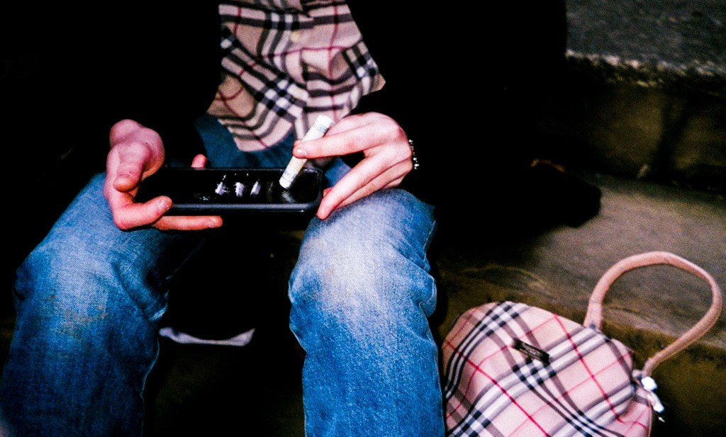 Person doing cocaine off a smartphone