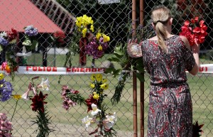 Perempuan meletakkan bunga di pagar tepi pantai Whakatane, Selandia Baru