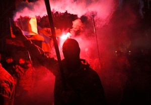 Fighters from the Azov volunteer battalion ignite flares during the march marking the 72nd anniversary of the Ukrainian Insurgent Army in Kiev, Ukraine, Tuesday, Oct. 14, 2014. (AP Photo/Sergei Chuzavkov)​