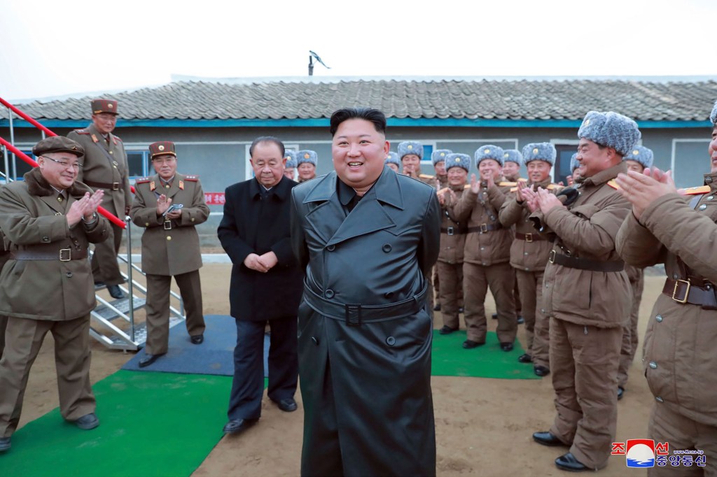 This undated file photo provided on Friday, Nov. 29, 2019, by the North Korean government, shows North Korean leader Kim Jong Un, center, surrounded by a military unit, reacts to what it claims as a test firing of its "super-large" multiple rocket launche