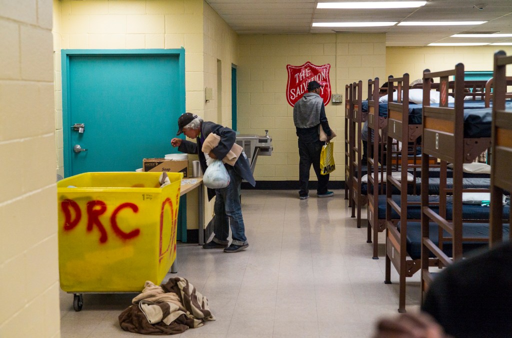 In this Tuesday, Oct. 15, 2019 photo, Patrons of The Salvation Army homeless shelter grab supplies near downtown Las Vegas.