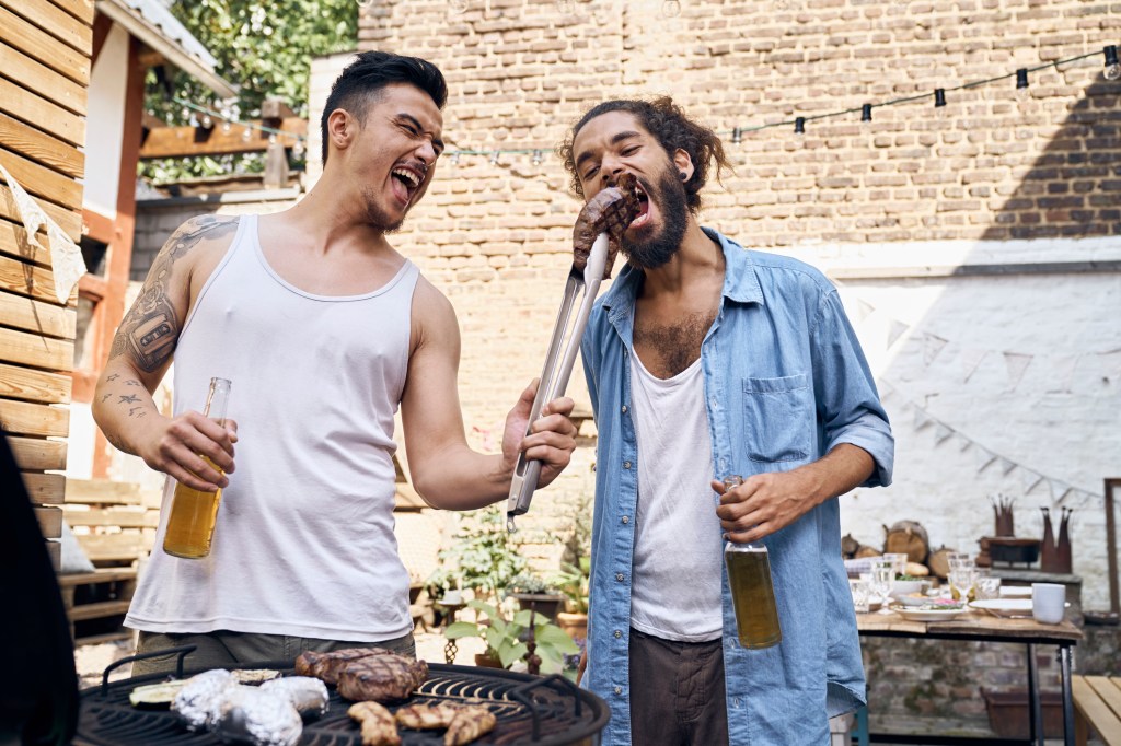 A man feeds his friend a steak