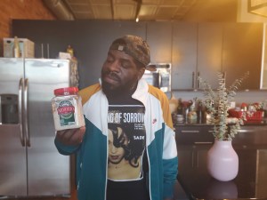 Hanif Abdurraqib holding container of risotto in kitchen