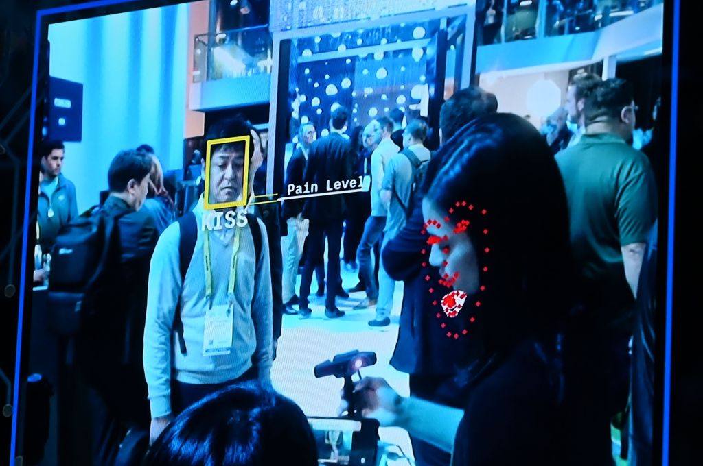 Facial recognition technology invasively scanning a person's face using biometrics to determine pain level.