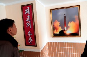 In this Nov. 26, 2019, photo, a man looks at a photo of the launch of a missile hanging on the wall of a factory workers' dormitory in Pyongyang, North Korea.