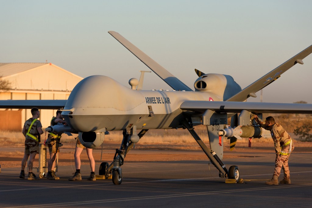 This photo provided by the French Defense Ministry communication center and taken Tuesday Dec. 17, 2019, shows French soldiers loading a French Reaper drone with two GBU 12 missiles on Niamey airbase, Niger.