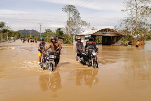 Automovilistas caminan por una carretera inundada, causada por las fuertes lluvias provocadas por e tifón Phanfone, en la ciudad de Ormoc, provincia de Leyte, en el centro de Filipinas, el 25 de diciembre de 2019.