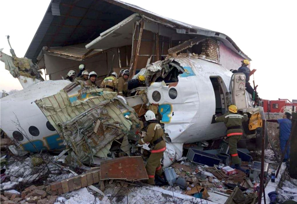 In this handout photo provided by the Emergency Situations Ministry of the Republic of Kazakhstan, police and rescuers work on the side of a plane crash near Almaty International Airport, outside Almaty, Kazakhstan, Friday, Dec. 27, 2019