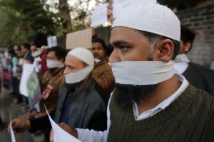 Indians cover their mouths during a protest against Sunday's assault by masked assailants at New Delhi's Jawaharlal Nehru University, in Delhi, in Ahmadabad, India, Monday, Jan. 6, 2020