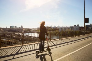 woman on e-scooter without a helmet