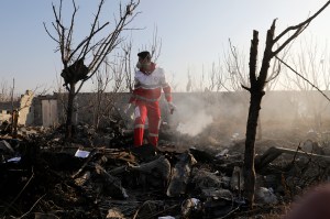 A rescue worker searches the scene where an Ukrainian plane crashed in Shahedshahr, southwest of the capital Tehran