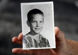 In this Wednesday, Aug. 21, 2019 photo, Greg Hunt holds a school photo of himself in St. Petersburg, Fla. Attorneys for victims from around the country of alleged childhood sex abuse by Boy Scout officials say they are preparing to sue the organization in