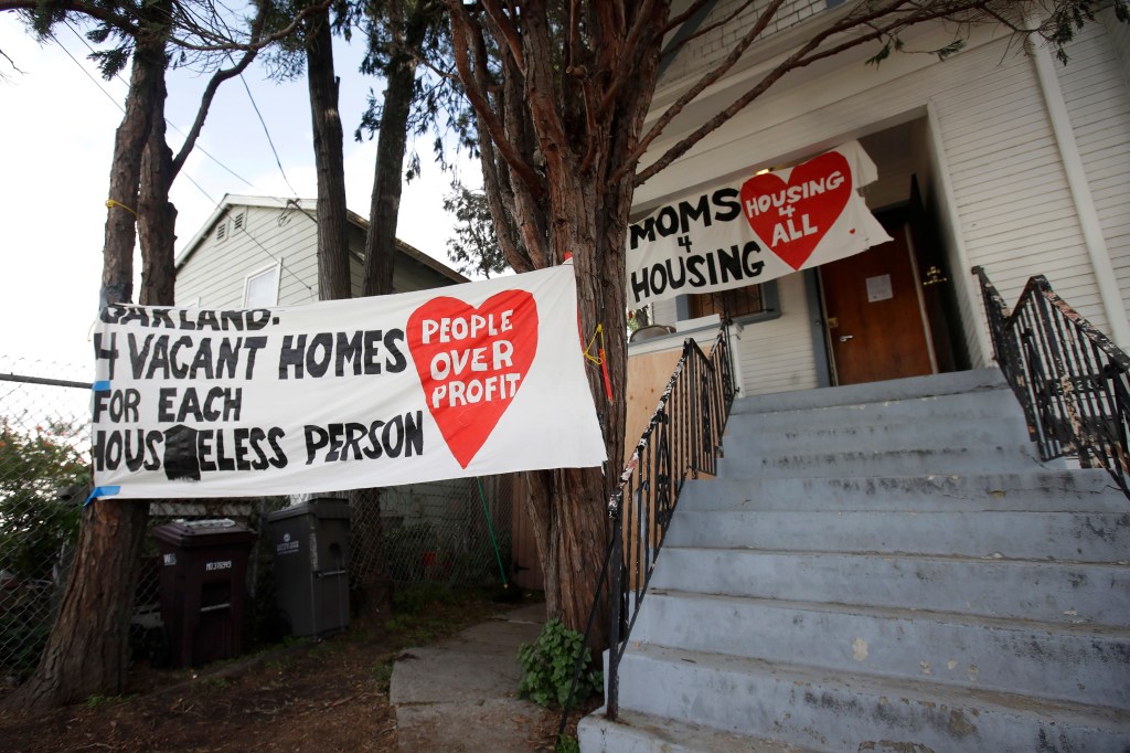 Signs are posted outside of a house that was occupied by homeless women in Oakland, Calif., Tuesday, Jan. 14, 2020. (AP Photo/Jeff Chiu)​