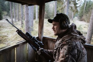 Der vegetarische Jäger Fabian Grimm mit mit Gewehr in einem Hochstand