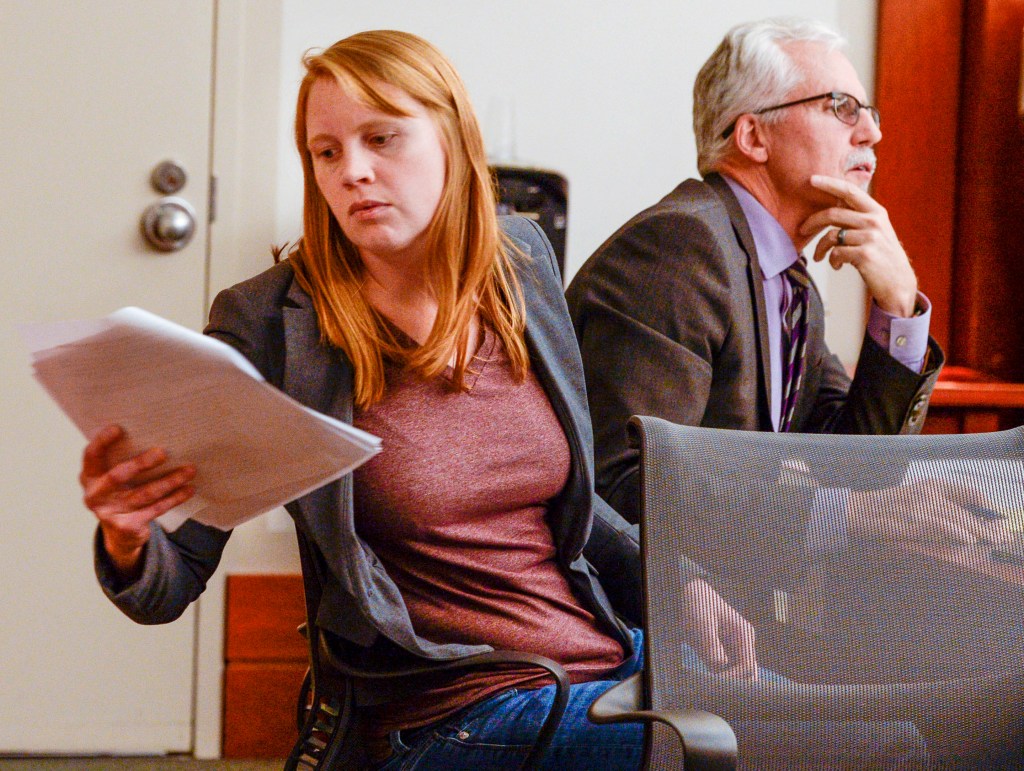 Tilli Buchanan, left, reads a document in court as she sits with Randy Richards, right, her attorney, during deliberations in a case where Buchanan was charged with criminal lewdness involving a child, in Salt Lake City.