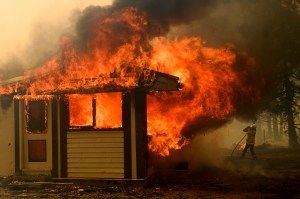 A firefighter battles the Morton Fire as it consumes a home near Bundanoon, New South Wales, Australia