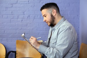 A transgender man filling out paperwork in the waiting room of a doctor's office