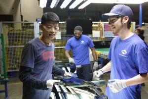 Wong He (left) working with Kenny Taylor (center) and Jarred Gibson (right) in the furnace tempering area of the Fuyao factory in Dayton, Ohio from the film AMERICAN FACTORY​.