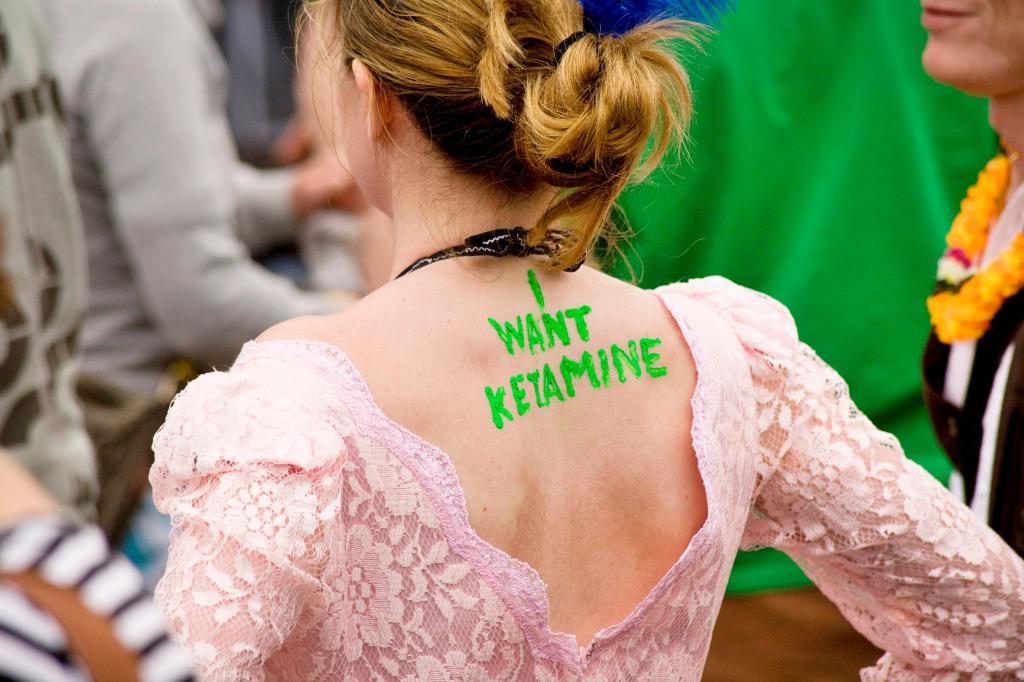 Girl with 'I Want Ketamine' written on her back at a music festival