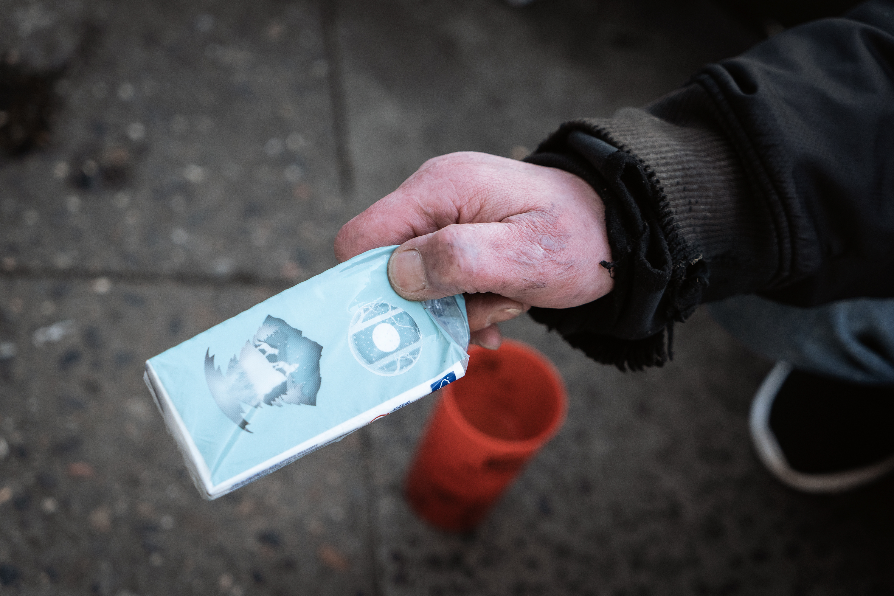 Eine Obdachlose zeigt Taschentücher