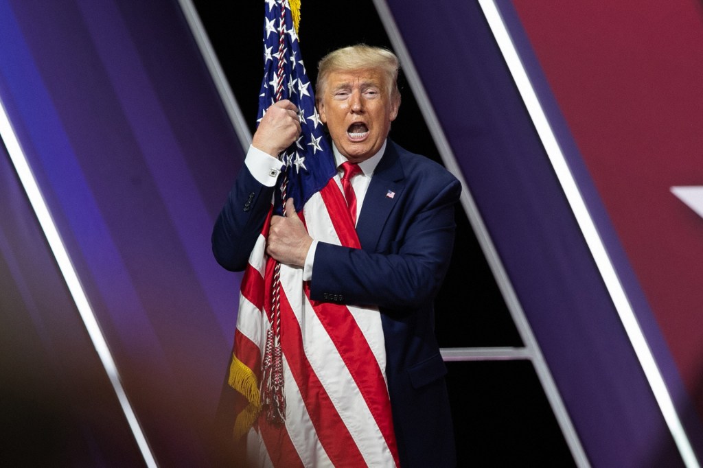 President Donald Trump hugs the flag of the United States of America at the annual Conservative Political Action Conference (CPAC) at Gaylord National Resort & Convention Center on February 29, 2020 in National Harbor, Maryland.