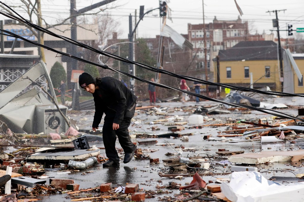 A man walks through storm debris following a deadly tornado Tuesday, March 3, 2020, in Nashville, Tenn.