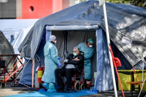 An elderly patient is attended in one of the emergency structures that were set up to ease procedures outside the hospital of Brescia, Northern Italy, Tuesday, March 10, 2020.