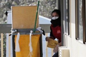 A hotel worker in cleaning gear.