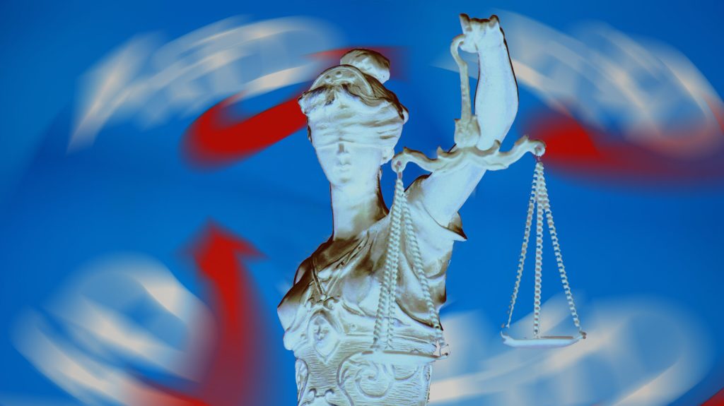 Justitia vor verschwommenen AfD-Logos