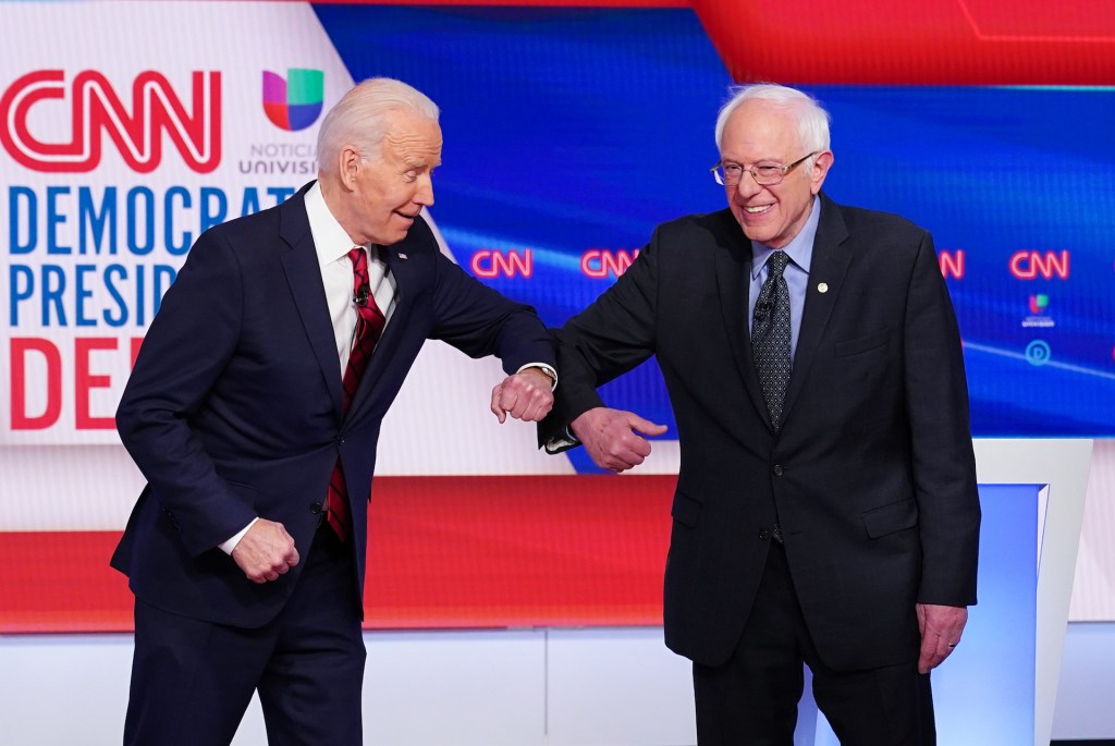 Democratic presidential hopefuls former US vice president Joe Biden and Senator Bernie Sanders greet each other with an elbow bump as they arrive for the 11th Democratic Party 2020 presidential debate