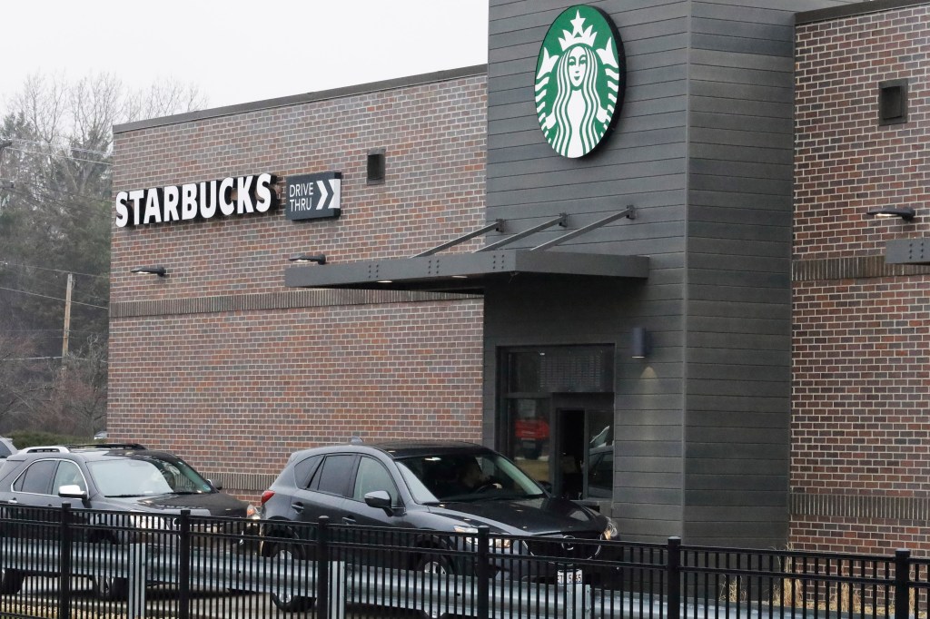 Customers wait for their order in their car at a Starbucks in Northbrook, Ill., Monday, March 16, 2020. Starbucks announced Sunday its company-owned stores across the U.S and Canada will shift to a "to go" model for at least two weeks to encourage social