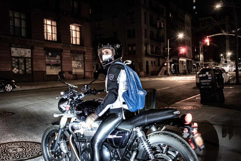 A motorcyclist wearing a face mask and helmet in locked down New York City.