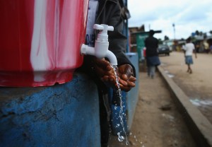 A man washing his hands at a tap.