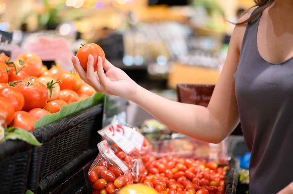 woman touching tomato food supermarket groceries