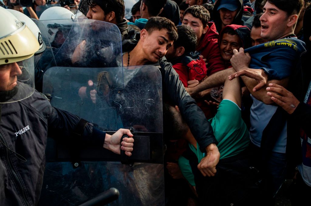 Migrants and refugees scuffle with riot police on the Greek island of Lesvos, on March 3, 2020. (Photo by ANGELOS TZORTZINIS / AFP) (Photo by ANGELOS TZORTZINIS/AFP via Getty Images)