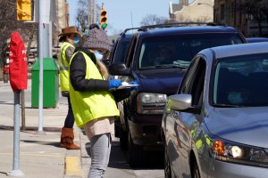 Volunteers wearing protective masks and gloves assist drivers waiting at an early voting ballot drop off location in Milwaukee, Wisconsin, U.S., on Thursday, April 2, 2020.