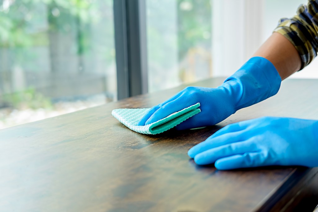 Cropped Image Of Person Cleaning Table At Home