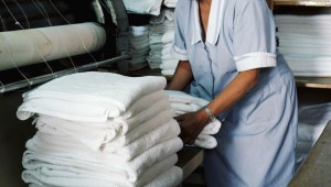 woman picking up folded towels