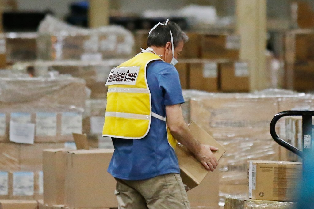 Cover: Fred Leighty, warehouse manager at Oklahoma's Strategic National Stockpile warehouse, carries a box at the warehouse Tuesday, April 7, 2020, in Oklahoma City. (AP Photo/Sue Ogrocki)