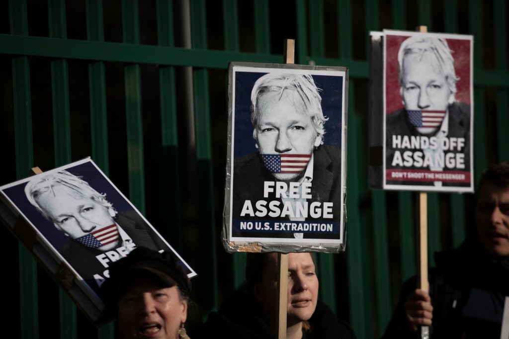 Supporters of Julian Assange hold placards as they protest on the second day of a week of opening arguments for the extradition of Wikileaks founder Julian Assange outside Belmarsh Magistrates' Court in south east London, Tuesday, Feb. 25, 2020. (AP Photo