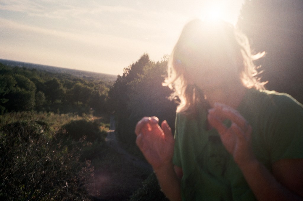 Woman with the sun shining behind her.