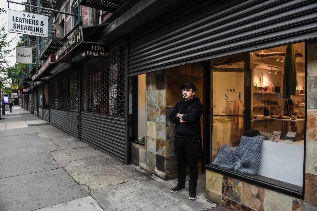 A business proprietor stands in front of his store on April 30, 2020 in the Lower East Side neighborhood in New York City.